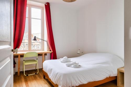 1 dormitorio con cama, escritorio y ventana en Plein centre de Nantes, appartement pour 4 en Nantes