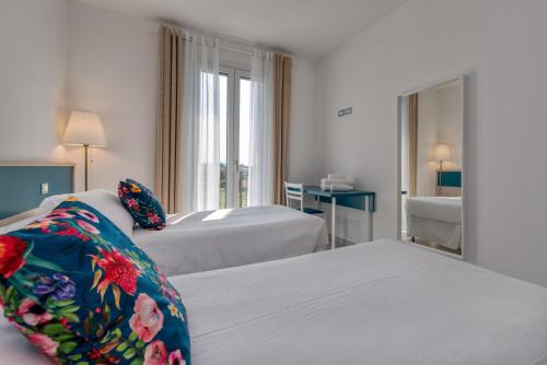 Habitación de hotel con 2 camas y espejo en Appartamenti Villa Campo Rosso en Colà di Lazise