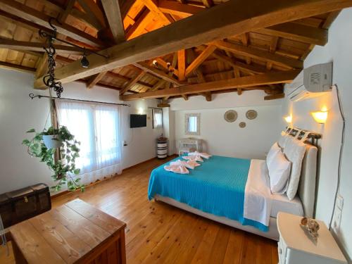 Schlafzimmer mit blauem Bett und Holzboden in der Unterkunft Agnanti Villas 1 in Isómata