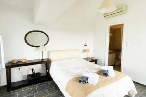 a bedroom with a bed with two towels and a mirror at TΟRRE DI PIETRA-LUXURY RESIDENCE-ΑMAZING SEA VIEW in Marathón