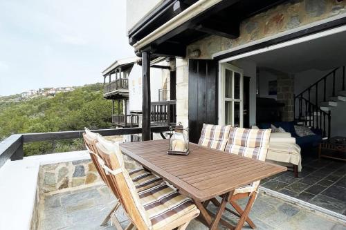 a wooden table and two chairs on a patio at TΟRRE DI PIETRA-LUXURY RESIDENCE-ΑMAZING SEA VIEW in Marathón