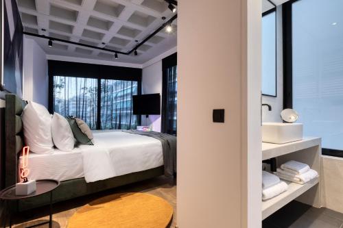 a bedroom with a large bed and a sink at Koniama Acropolis in Athens