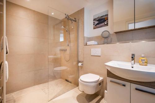 ein Badezimmer mit Dusche, Toilette und Waschbecken in der Unterkunft Haus Deichkieker Apartment 1 4 in Büsum