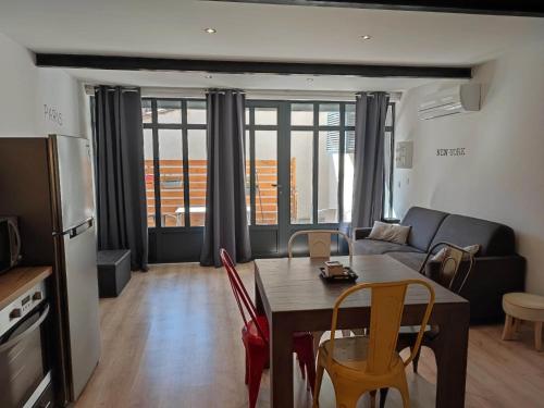 un salon avec une table, des chaises et un canapé dans l'établissement La Bastide de Gabin / ConciergerieDameCarcas, à Carcassonne