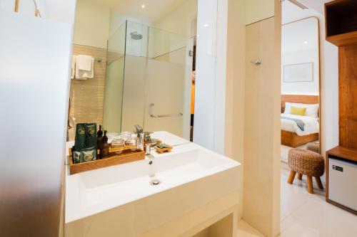 1 dormitorio y baño con lavabo blanco. en Umpadhi Canggu, en Canggu