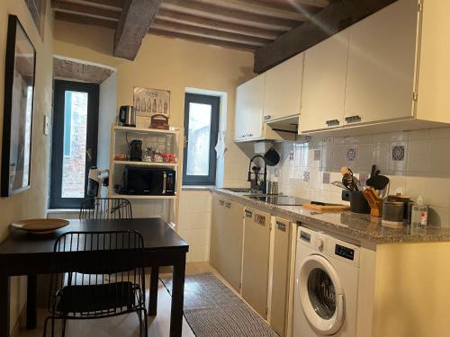 Saturnia Country Loft Montemerano ( Terme a 6 km) في مونتيميرانو: مطبخ مع غسالة وطاولة