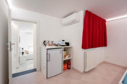 een keuken met een koelkast en een rood gordijn bij Deluxe Suites in Piano di Sorrento