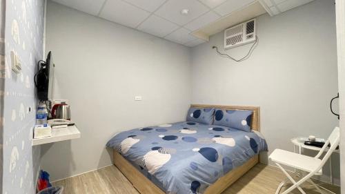 1 dormitorio pequeño con 1 cama y 1 silla en 漫旅溫泉會館-愛娜, en Jiaoxi
