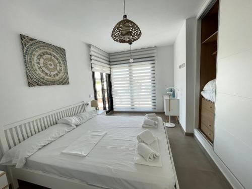 um quarto com uma grande cama branca com toalhas em Villa Bali 3034 em Vistabella