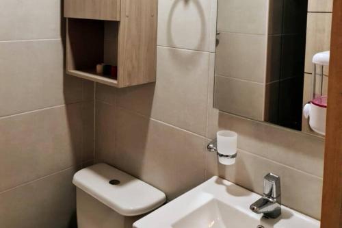 Un baño con lavabo, inodoro y espejo. en Hermoso mini apartamento en el corazón de Bogotá, en Bogotá