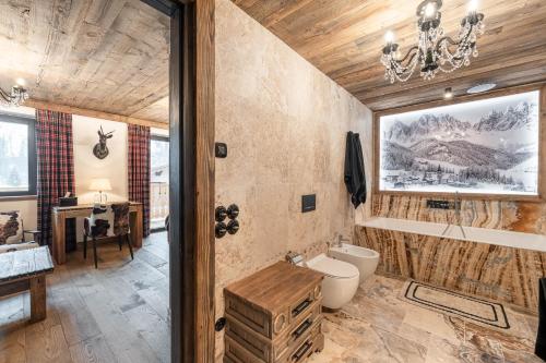 uma casa de banho com um WC e um lustre em Belvedere Elite em Canazei