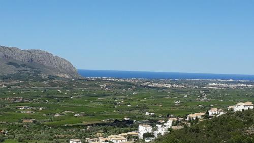 einen Blick auf ein Tal mit Häusern und das Meer in der Unterkunft Casa Jacaranda in Orba