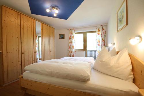 1 Schlafzimmer mit einem weißen Bett und einer blauen Decke in der Unterkunft Almliesl LEOG-685 in Leogang