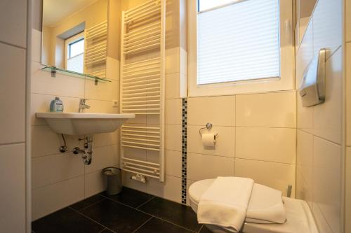 La salle de bains est pourvue d'un lavabo, de toilettes et d'une fenêtre. dans l'établissement Haus Nordseetraum Wohnung 5, à Büsum