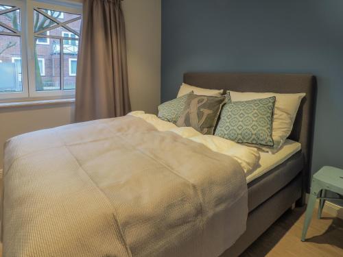 een bed in een kamer met een raam bij Strandpalais Apartment Landgang in Büsum