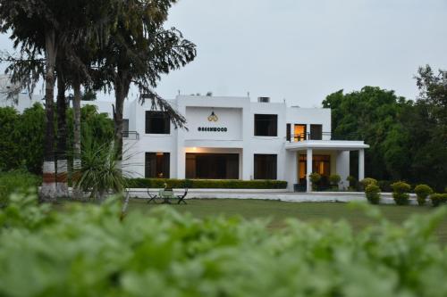 een wit huis met een bord erop bij Greenwood Hotel in Khajurāho