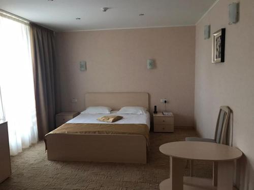 a hotel room with a bed and a table and a table sidx sidx at Жеруйык Отель in Aktau