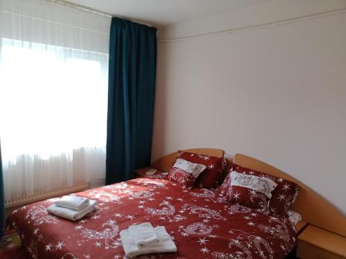 a bedroom with a red bed with towels on it at Flat 4you & WI-FI in Arad