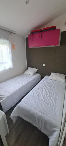 2 łóżka w sypialni z różową półką w obiekcie mobil-home 6 places w mieście Biscarrosse
