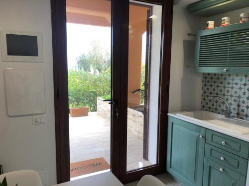 a kitchen with a door leading to a patio at BREZZA DI LEVANTE in Cefalù