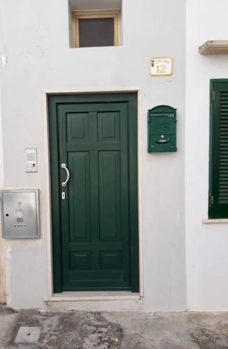 a green door on the side of a building at casa Pumi nel centro storico di Nardo' con terrazza panoramica in Nardò
