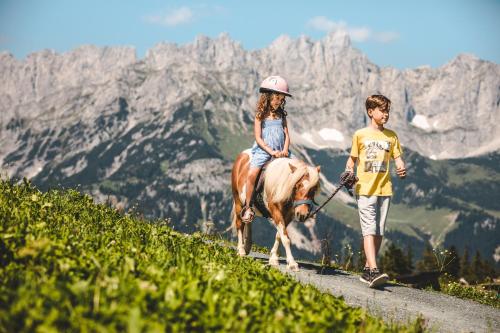a boy and a girl riding a horse on a mountain at Residenz Theresa in Söll