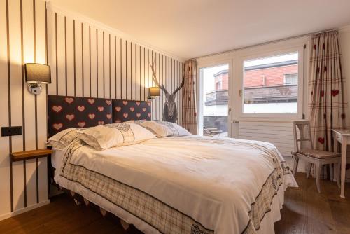 a bedroom with a large bed and a window at Home Hotel Arosa in Arosa