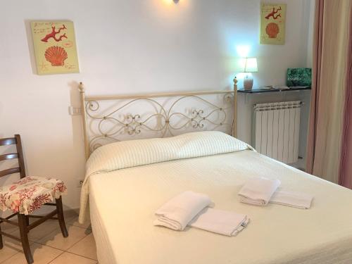 a bedroom with a white bed with two towels on it at Appartamenti Sentiero n1 in Levanto