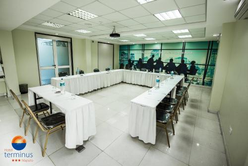 a conference room with white tables and chairs and people at Hotel Terminus Maputo in Maputo