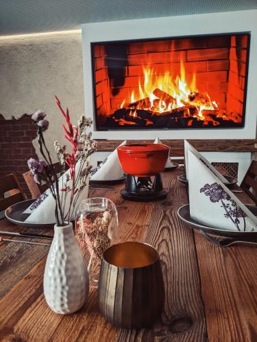 a wooden table with a fireplace in the background at Hofgut Algertshausen in Eresing