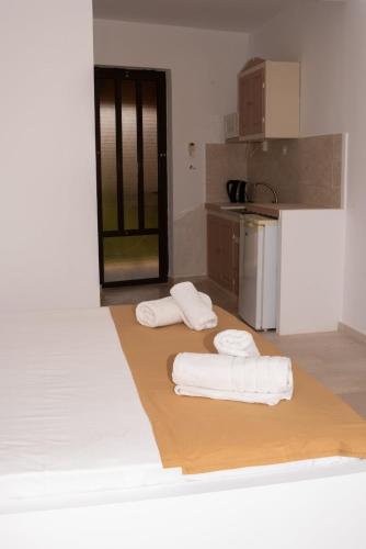 una cocina con 2 toallas blancas en el suelo en Sofia Studios, en Laganas