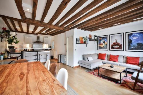 ein Wohnzimmer mit einem Holztisch und einer Küche in der Unterkunft Typical Parisian Duplex#4pers#Le Marais in Paris