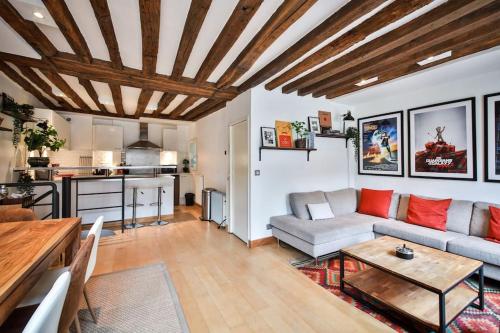 ein Wohnzimmer mit einem Sofa und einem Tisch in der Unterkunft Typical Parisian Duplex#4pers#Le Marais in Paris