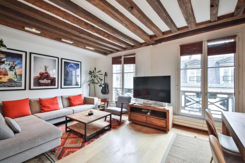 un salon avec un canapé et une télévision à écran plat dans l'établissement Typical Parisian Duplex#4pers#Le Marais, à Paris