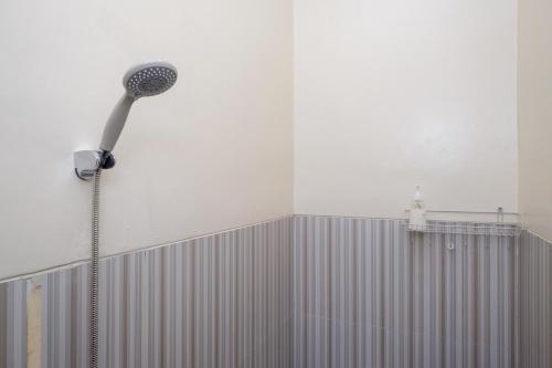 La salle de bains est pourvue d'un pommeau de douche mural. dans l'établissement RedDoorz Syariah near Perempatan Kartasuro, à Solo