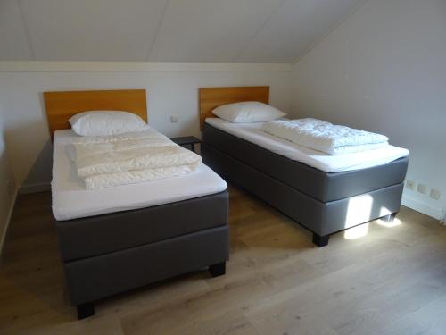 two beds in a room with two beds sidx sidx sidx sidx at Kustverhuur, Park Scheldeveste, Schelde 76 in Breskens