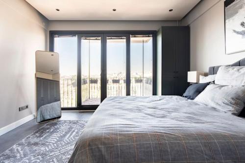 a bedroom with a large bed and large windows at SVM suites With a sea view in nişantaşı in Istanbul