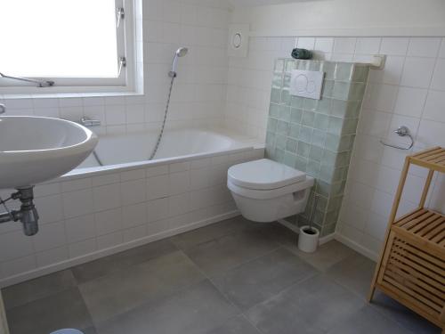 a bathroom with a sink and a toilet and a tub at Kustverhuur, Park Scheldeveste, Schelde 76 in Breskens