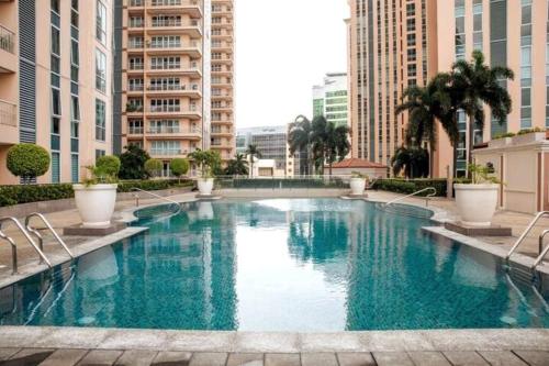 a large swimming pool in a city with tall buildings at Cozy 2-bedroom in The Venice Luxury Residences in Manila