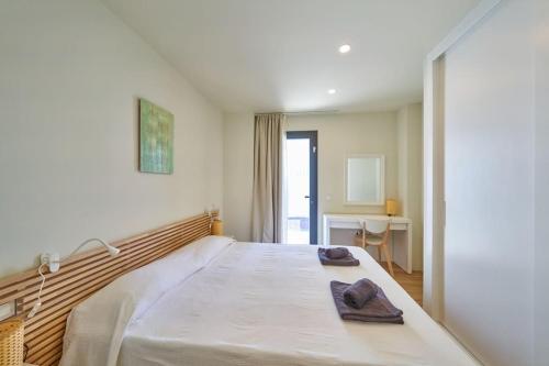 a bedroom with a large bed with towels on it at Namasté in San José