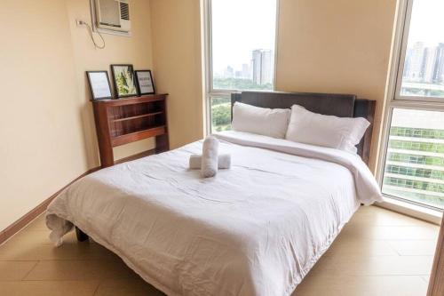 a bedroom with a large bed with two candles on it at Cozy 2-bedroom in The Venice Luxury Residences in Manila