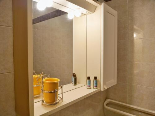 un bagno con specchio su una mensola nella doccia di Cardellino, piccolo e accogliente dietro la spiaggia a Grado