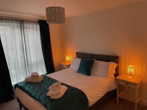 a bedroom with a bed with two towels on it at Number 15 Luxurious Two Bedroom Apartment in Exmouth