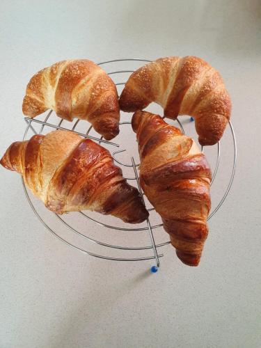 four croissants on a plate on a table at B&B Casa Sara in Cassano dʼAdda