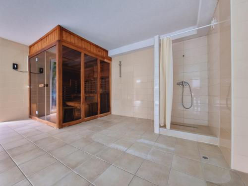 a bathroom with a shower and a tiled floor at Andi Apartman in Siófok