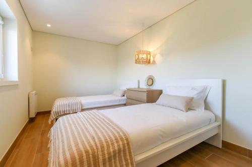 Habitación blanca con cama y mesita de noche en Pé Na Duna - beachfront apartment, en Viana do Castelo