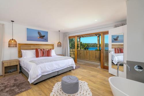 a bedroom with a bed and a view of the ocean at In Toto Retreat - Garden Route in Sedgefield