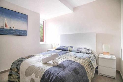 a bedroom with a bed and a sailboat painting on the wall at Apartamento único en Muralla Roja - 0412 in Calpe