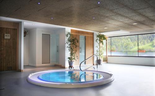 a hot tub in a room with a large window at Apartaments Els Llacs in Bordes d´Envalira