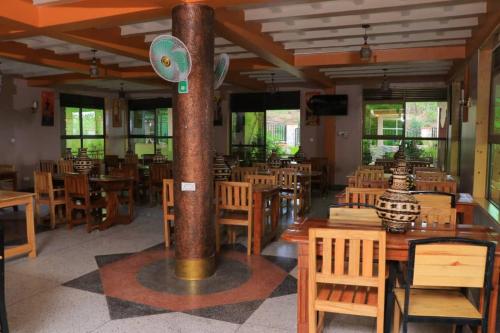 una sala da pranzo con tavoli e sedie in legno di Dreamwood suites Mbarara a Mbarara